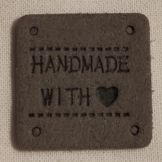 Keinonahkainen harmaa neliö handmade-merkki.