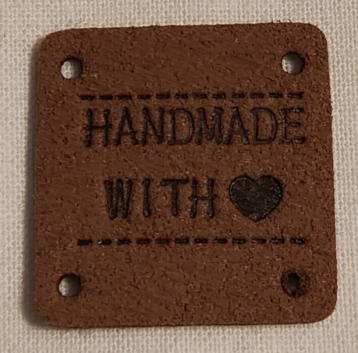 Keinonahkainen ruskea neliö handmade-merkki.