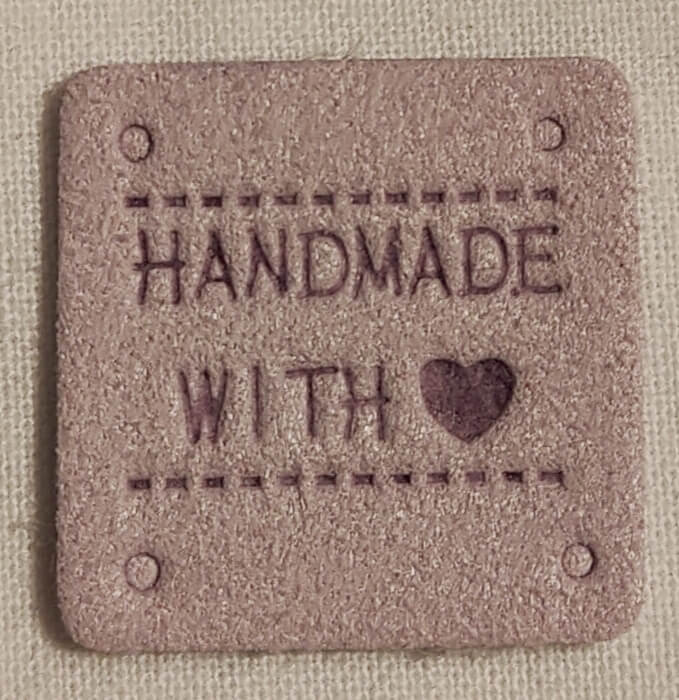 Keinonahkainen vaalea lila neliö handmade-merkki.
