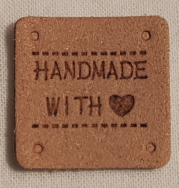 Keinonahkainen vaaleanruskea neliö handmade-merkki.